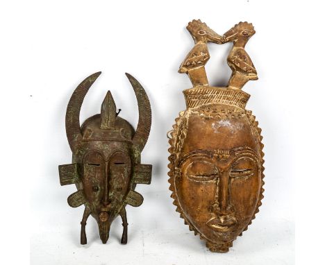 An African patinated verdigris bronze mask, height 30cm, and a carved wood Tribal mask (2) 