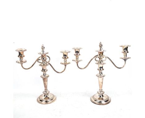 A pair of silver plated three-light candelabra, with gardooned rims, flame finial centre sconces and removeble sconces to con
