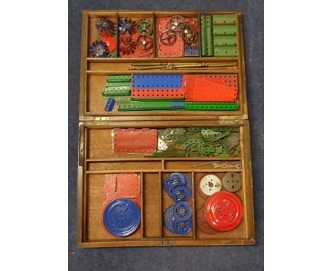 Meccano accessory outfit in a wooden box including strips, plates, ball/roller bearings, circular parts etc.