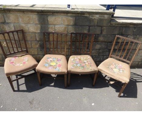 A set of four Georgian mahogany dining chairs with floral tapestry upholstered overstuffed seats, raised on square tapering s