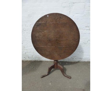 A Georgian four plank circular tilt-top table, raised on a turned column to a tripod base. 