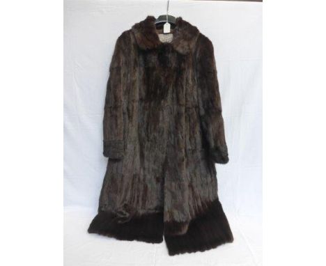 A ladies fur coat bearing retailers label Michaels of Bristol, a fur stole, a Doeland of London dress with beaded decoration 