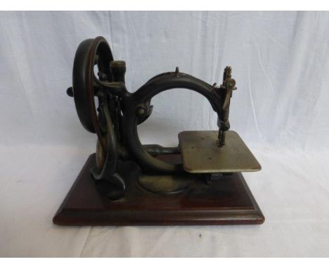 A Willcox & Gibbs sewing machine with medallion attached set on a mahogany base. 