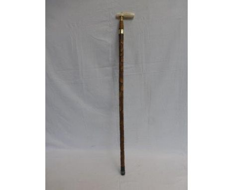 An ivory handled walking stick with carved foliage decoration. 