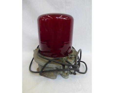 A heavy duty cast metal and red glass lamp, possibly nautical. 