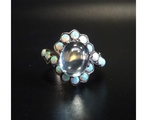 UNUSUAL OPAL AND MOONSTONE DRESS RINGthe central oval cabochon moonstone in opal surround with twist setting, on fifteen cara