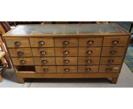 1950s MIXED WOOD AND GLAZED DISPLAY CABINETwith nineteen cup handled drawers to one side, brass measuring rule inset to top e