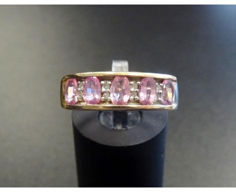 PINK SAPPHIRE AND DIAMOND RINGthe five oval cut sapphires separated by small diamonds, on nine carat gold shank with channel 