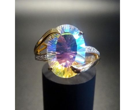 MYSTIC TOPAZ AND DIAMOND DRESS RINGthe central oval cut topaz flanked by diamond set twist design split shoulders, in nine ca