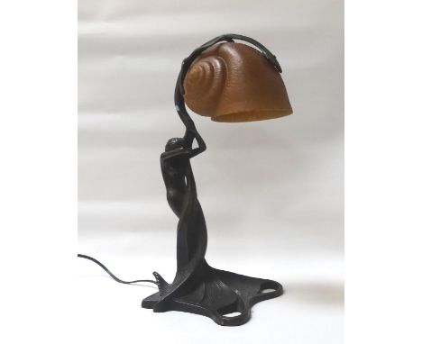 ART NOUVEAU STYLE LAMPdepicting a nude maiden holding a naturalistic tree trunk, the trunk with a dark yellow shell shaped gl