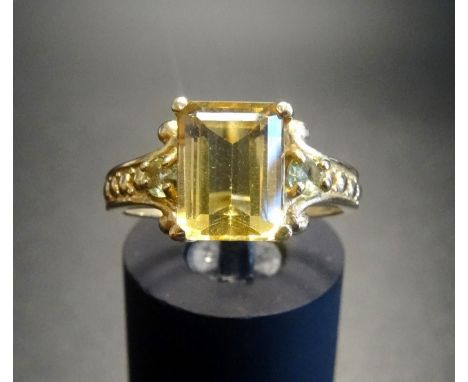 YELLOW BERYL AND PERIDOT RINGthe emerald cut beryl flanked by small round cut peridots, on nine carat gold shank with attract