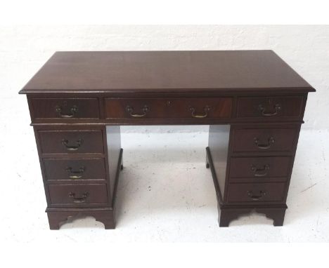MAHOGANY KNEEHOLE DESKwith three single drawers, three drawer pedestals, raised on bracket style supports, 122.7cm wide, with