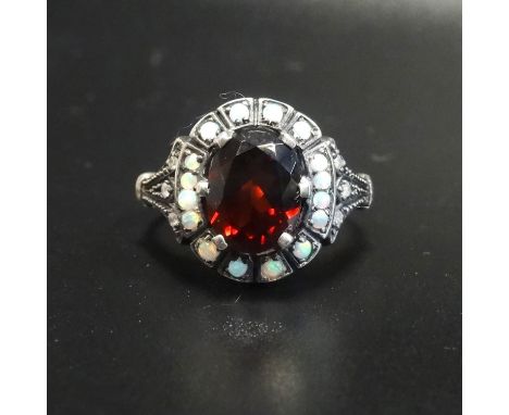 GARNET, OPAL AND DIAMOND CLUSTER RINGthe central oval cut garnet in opal surround with small diamonds to the shoulders, on un