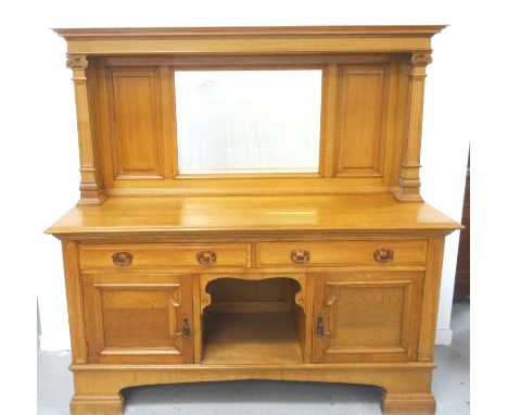 ARTS AND CRAFTS OAK MIRROR BACK SIDEBOARDwith a moulded top supported by two tapering square columns with carved capitals, wi