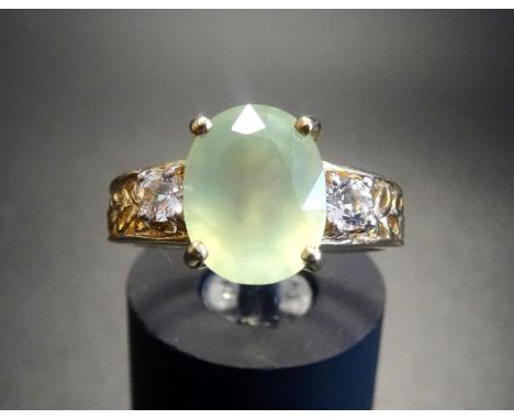 PRASIOLITE AND CLEAR GEM SET DRESS RINGthe central oval cut prasiolite flanked by clear gemstones, on nine carat gold shank w