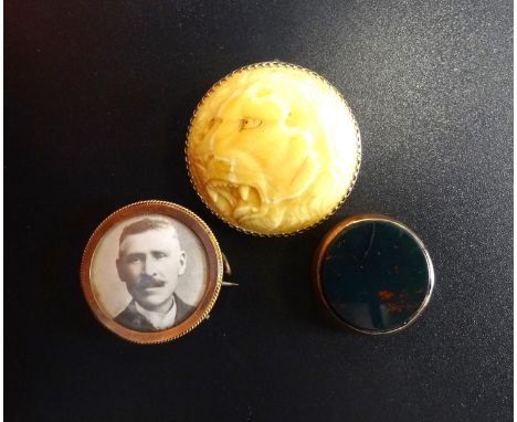 TWO GOLD MOUNTED BROOCHESone with carved lion decoration, the other a photograph panel; together with a Masonic swivel fob (m