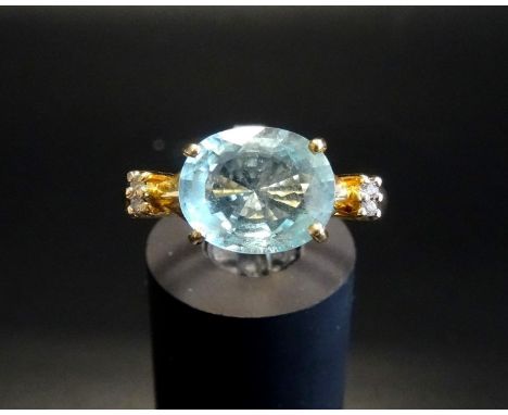 AQUAMARINE AND DIAMOND DRESS RINGthe central oval cut aquamarine approximately 3cts flanked by two diamonds to each shoulder,