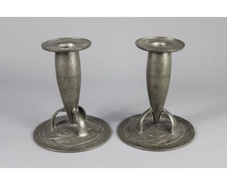 Liberty - Pair of Turdric Pewter Candlesticks; the bullet-shaped candlesticks resting on tripod supports and floral base, app