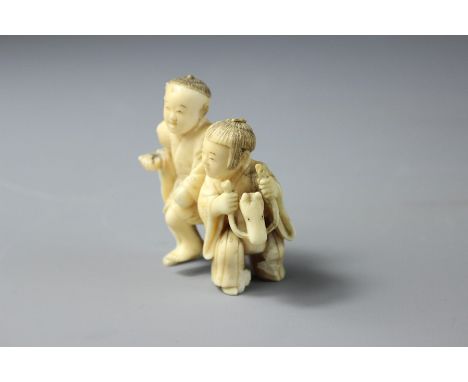 A 19th Century Japanese Ivory Netsuke, carved as figures riding a donkey, approx 5 x 5.5 cms. (af)