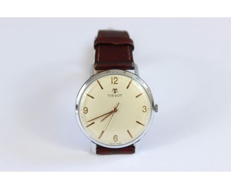 A Tissot Gentleman's Wrist Watch; the watch having a champagne face with numeric and baton dial, on brown leather strap.
