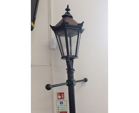 A Metal Garden Lamp; the glass and metal lamp on a pole measuring approx 214h x 67 cms base measurement.&nbsp;