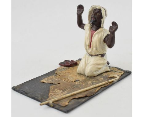 A vintage novelty hand-painted spelter model of a man knelling of prayer mat. Sprung head. Baes 7cm x 10cm.  In good original