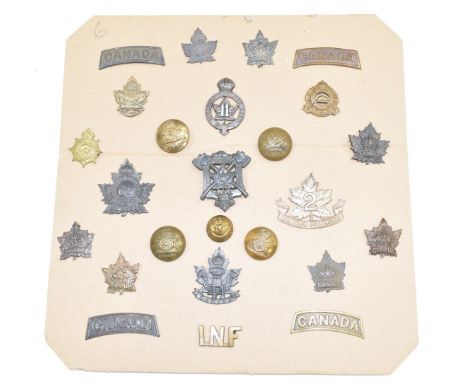 A carded display of approximately twenty five WW1 Canadian Army insignia including artillery buttons