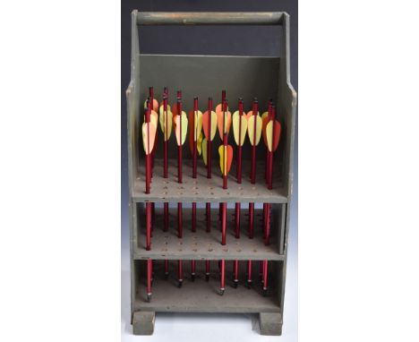 A collection of vintage archery arrows in wooden stand