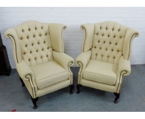 A pair of cream upholstered button back wing armchairs on cabriole supports, 106 x 94cm