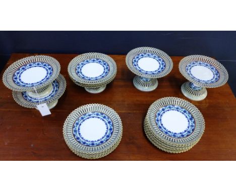 A Continental porcelain dessert service with reticulated rims and blue and white floral borders comprising five footed compor