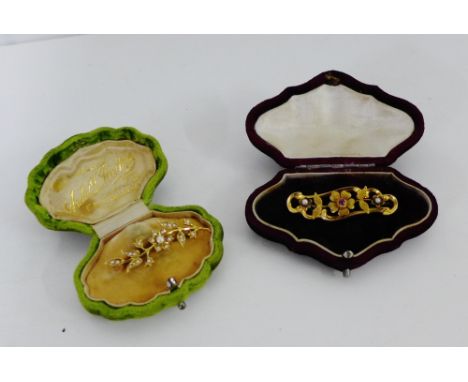 An Edwardian 15 carat ruby and seed pearl set brooch, Chester 1907 and another 15 carat gold seed pearl flowerhead brooch (2)