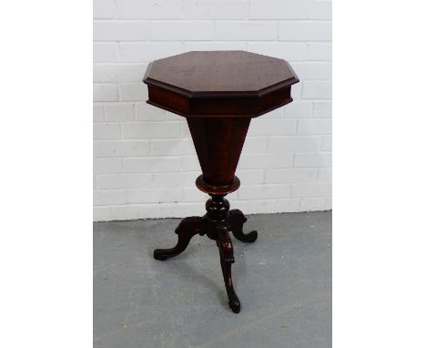 A walnut octagonal workbox, raised on fluted column and carved tripod supports, 75 x 44cm 
