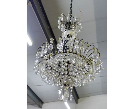A glass chandelier with three candle branches and hanging lustres