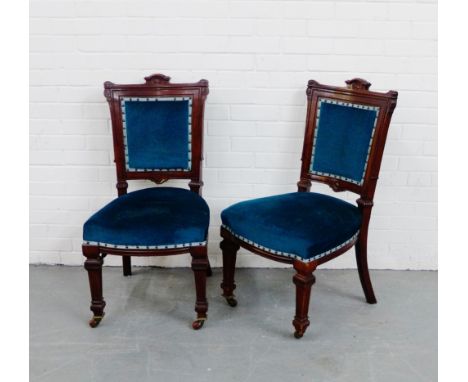 A pair of mahogany framed side chairs each with an architectural top rail, upholstered backs and seats and raised on square t