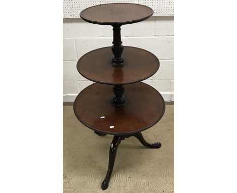 A late George III mahogany circular three tier dumb waiter each of the dished tiers on writhen carved and turned centre colum