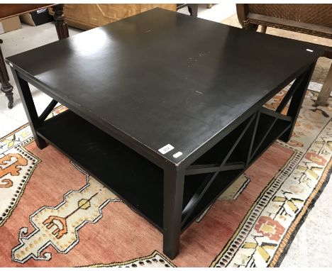 An OKA black lacquered coffee table, on square supports, united by an undertier, bears label "OKA 000724", 91 cm wide x 91 cm