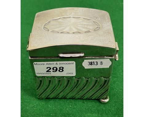 An Edwardian silver dome top rectangular tea caddy with semi-gadrooned embossed decoration, raised on four squat bun feet (by