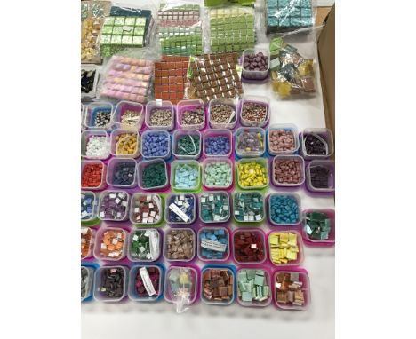 Four plastic boxes containing a large quantity of assorted and stored glass and other material mosaic tiles, together with ti