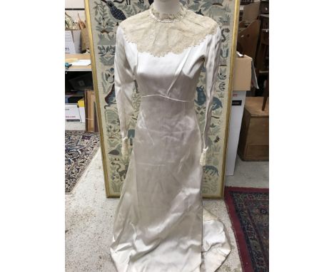 A 1950s oyster coloured duchesse satin wedding dress by Molly Stovell of Haywards Heath with vintage lace and pearl collars a