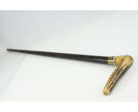 An antler handled walking stick with brass mount.