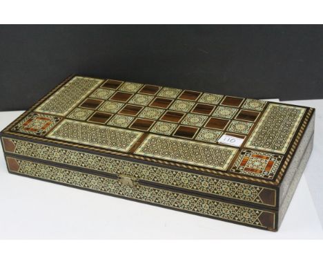 Two Wooden Games Boxes inlaid with bone and mother of pearl, each containing draughts pieces and dice, largest 50cms long