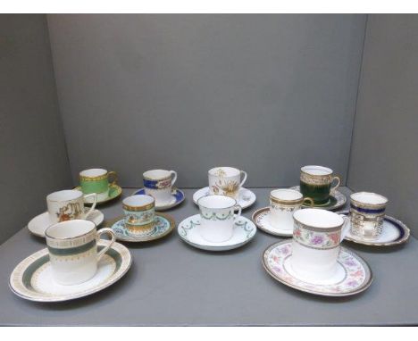 Eleven decorative coffee cans and saucers including one with a silver hallmarked holder. 