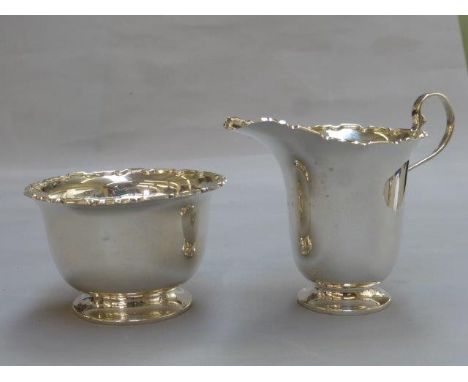 A silver cream jug and a silver sugar bowl forming a strawberry set, maker R & S Ltd. Birmingham 1938. 
