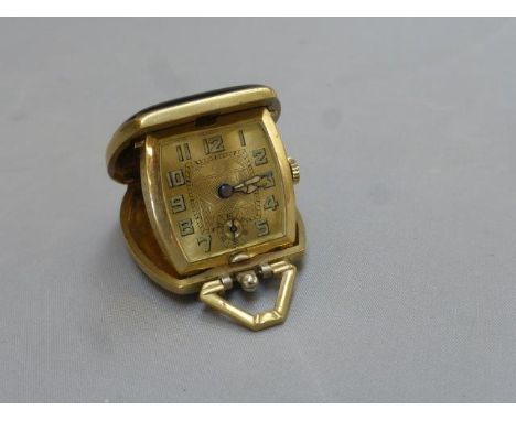 An unusual Art Deco travelling clock - when closed in the form of a handbag, the handle forming a hanging mount for use as a 