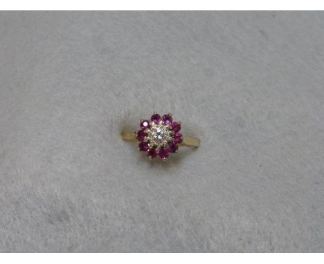 An 18ct gold ruby and diamond cluster ring, size L. 