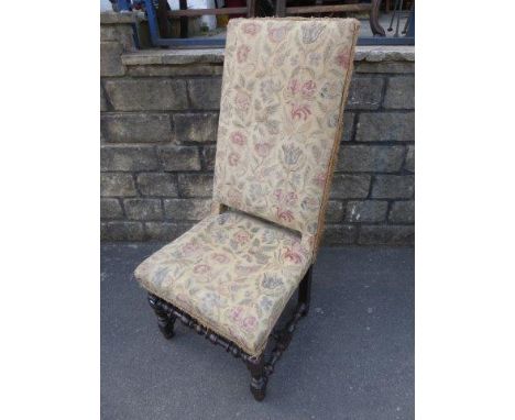 An 18th Century walnut high back chair with a floral tapestry cover.