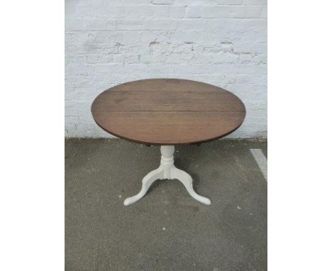 A Georgian oak circular tilt-top table with a painted tripod base. 