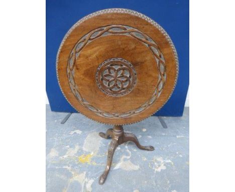 An 18th Century mahogany circular tilt top tripod table with later carved decoration, raised upon a bird cage to a turned col