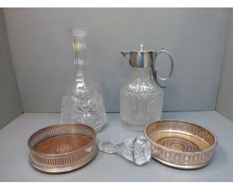 A good quality cut glass and silver plated claret jug, a crystal decanter and two silver plated wine coasters.