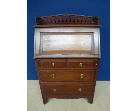 An Edwardian mahogany writing bureau, the fall front above two short and two long drawers, raised upon bracket supports. 